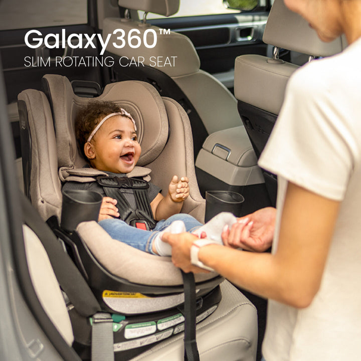 Britax Galaxy360 Slim Rotating Convertible Car Seat - Teak - caregiver buckling a rear-facing child 