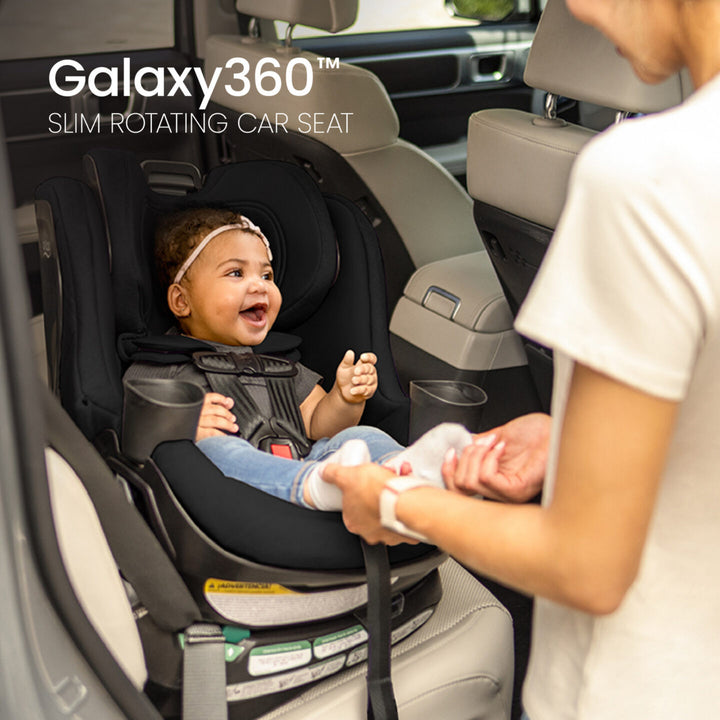 Britax Galaxy360 Slim Rotating Convertible Car Seat - Raven Black - caregiver buckling a rear-facing child 
