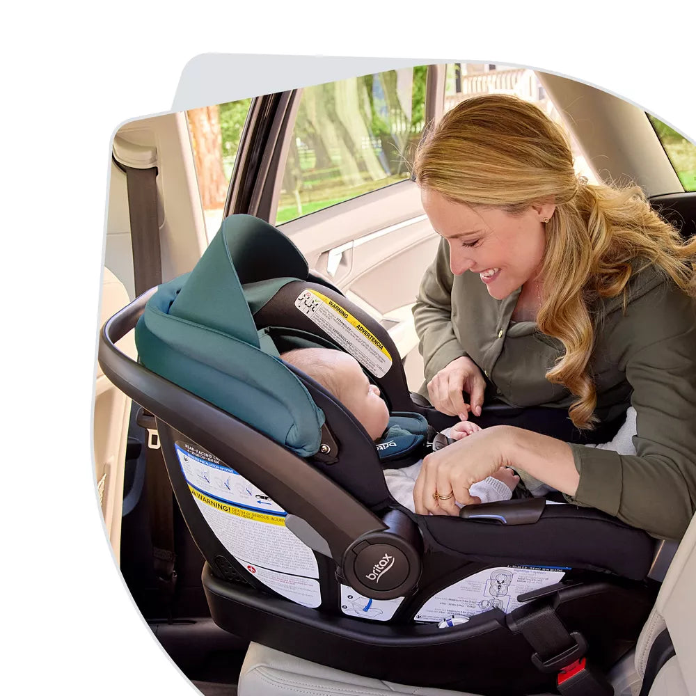 Parent helping baby into the Britax Willow infant car seat