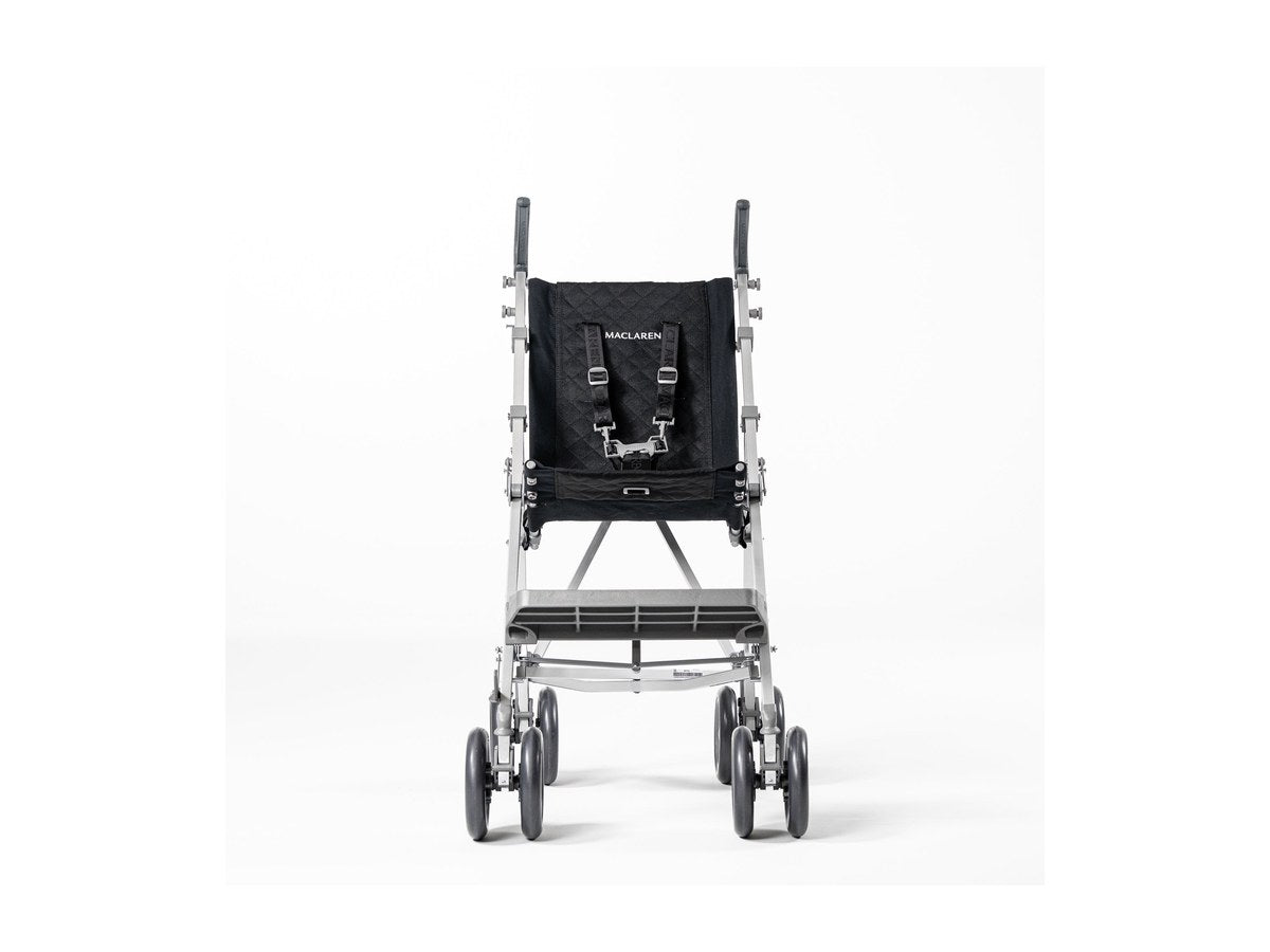 A child in a Maclaren Major Elite push chair on a city sidewalk