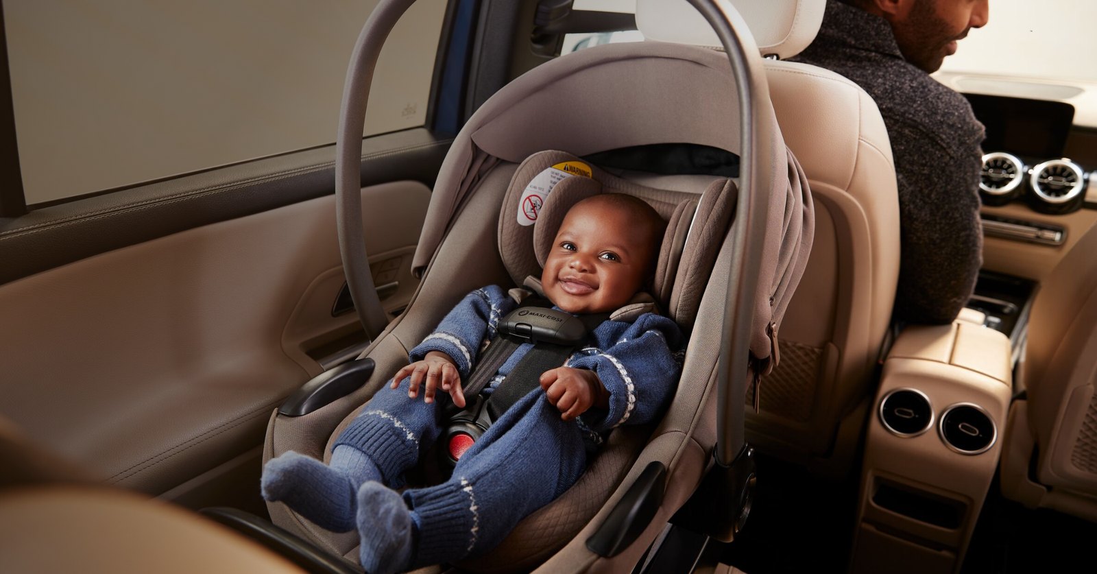 Baby smiling in a Maxi-Cosi car seat