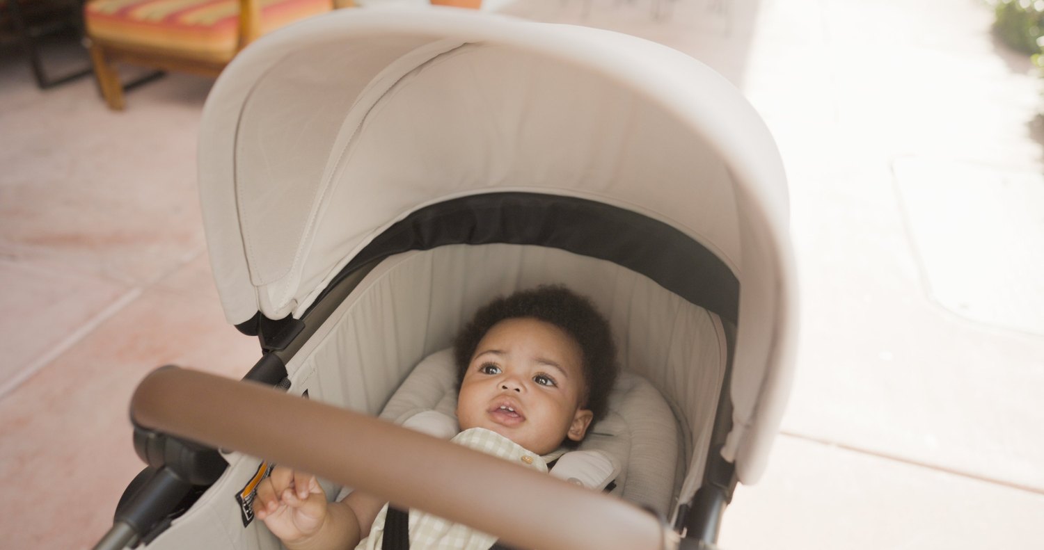 Baby riding in a Maxi-Cosi stroller outdoors