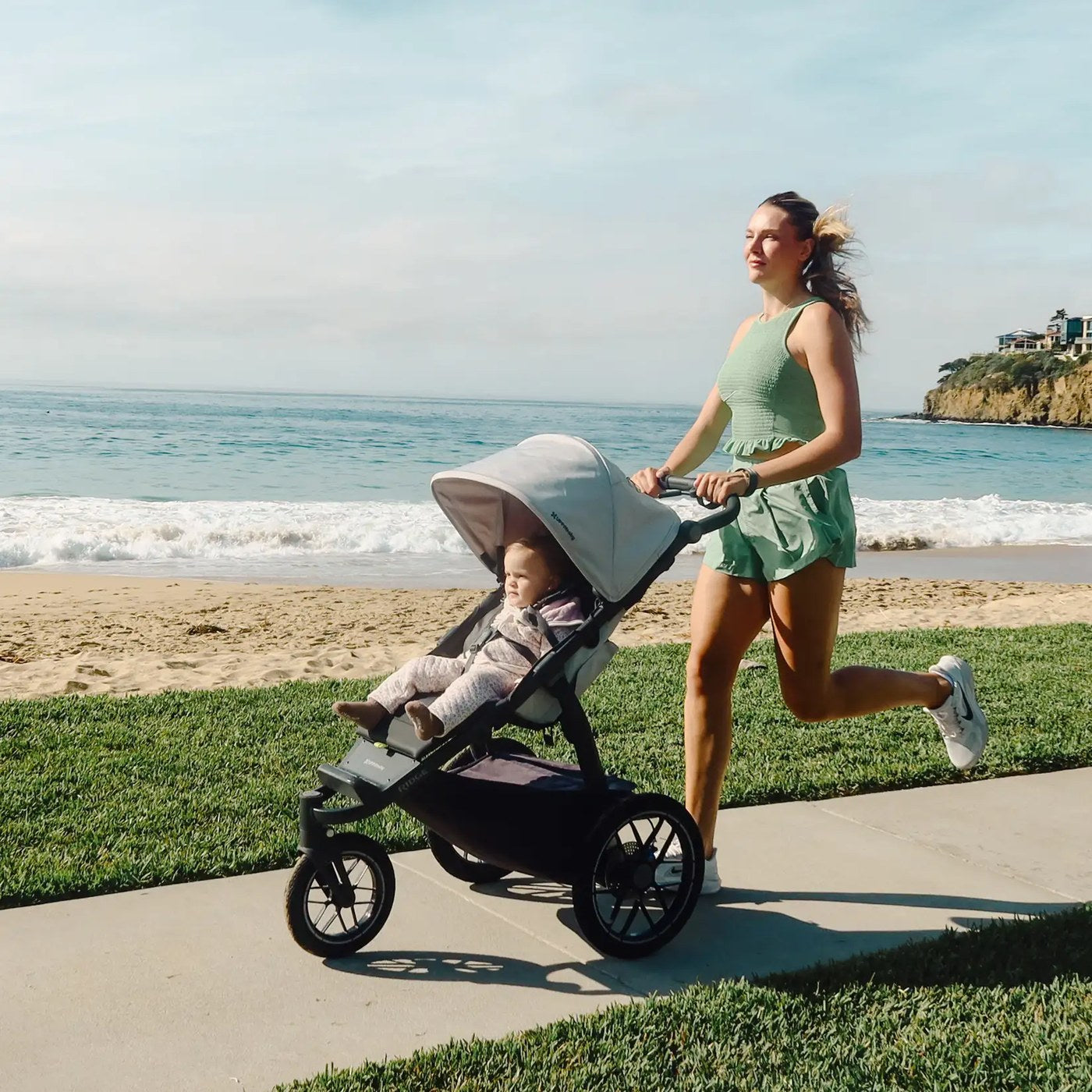 Parent jogging on a boardwalk with an UPPAbaby all-terrain stroller