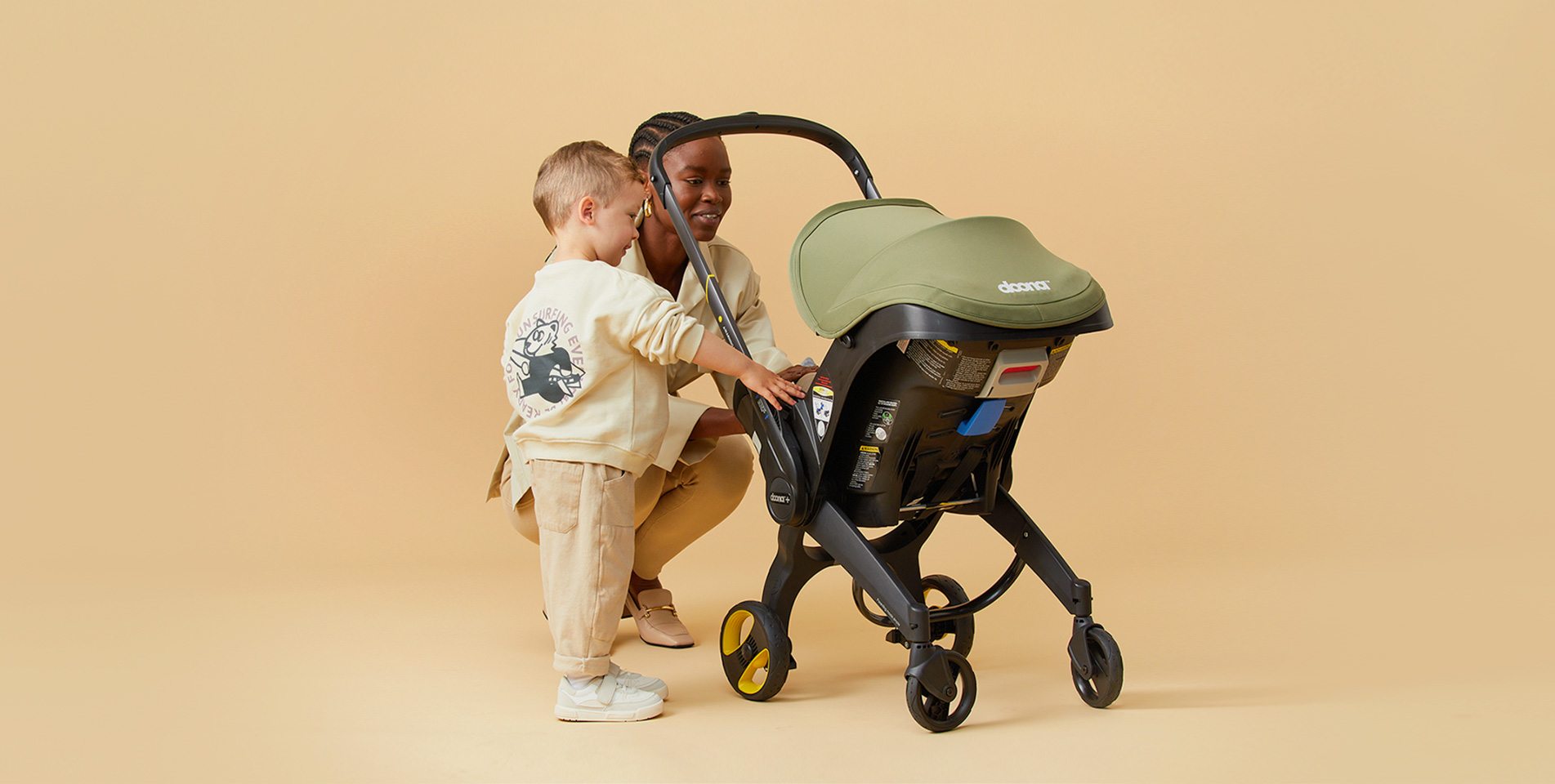 Mother and toddler with a Doona stroller in a warm studio setting