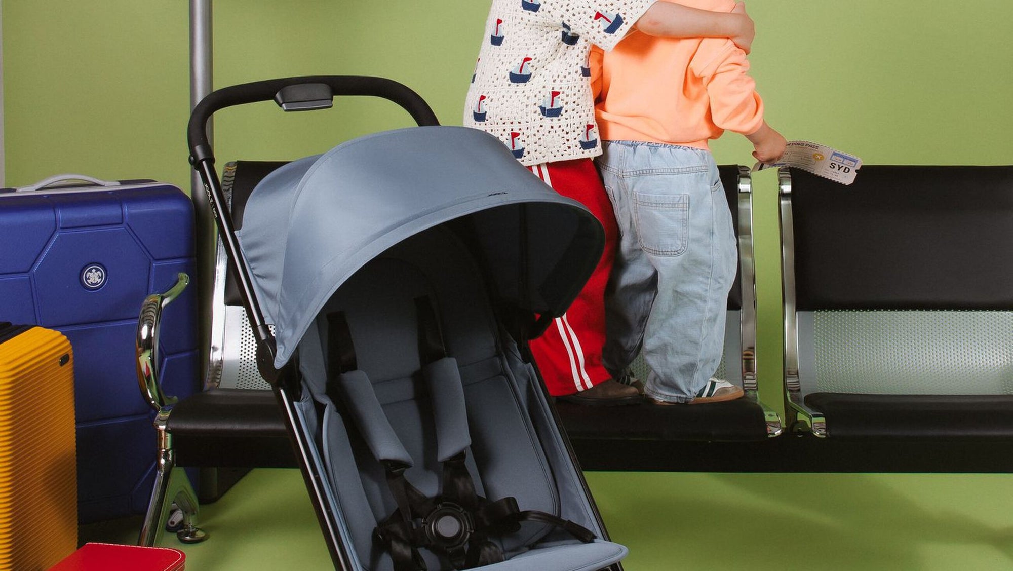 Two kids and a Joolz Dot stroller waiting at the airport gate
