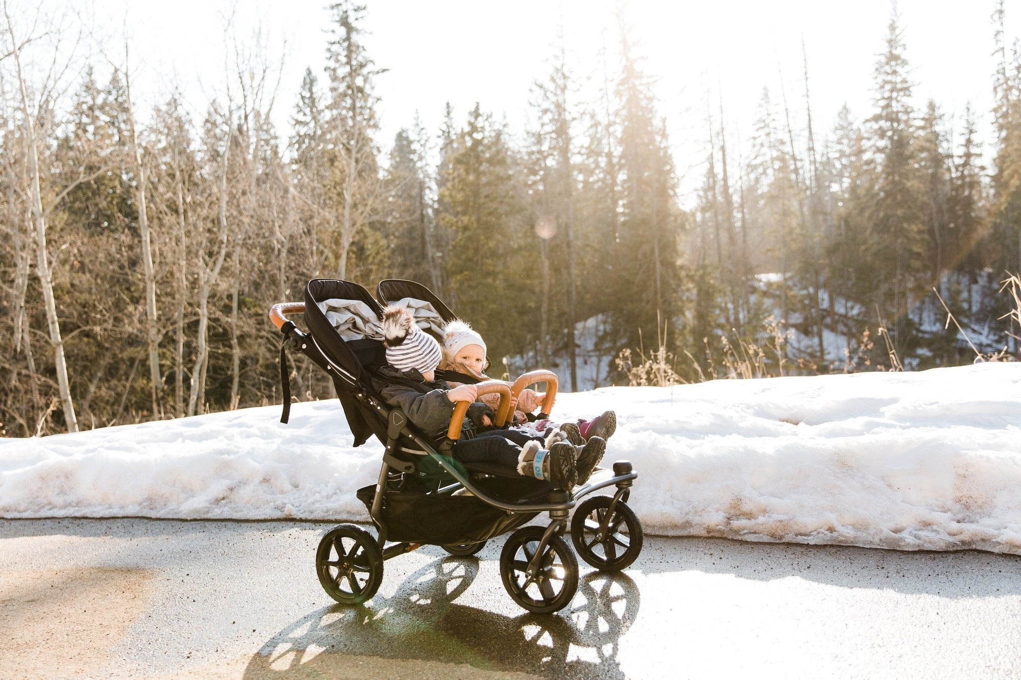 Mother and toddler walking with a Valco Baby stroller in the park